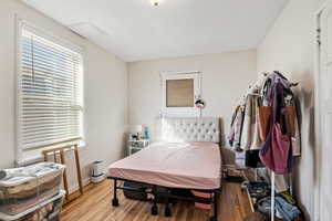 Bedroom with wood finished floors and baseboards