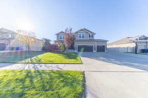 View of front of house featuring board and batten siding, driveway, an attached garage, and stone siding