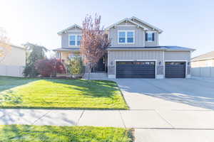 View of front facade with board and batten siding, concrete driveway, and a garage