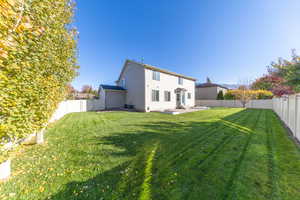 Rear view of house featuring a patio area and a fenced backyard