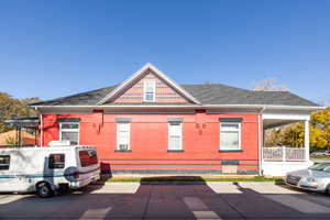 View of property exterior with brick siding and roof with shingles