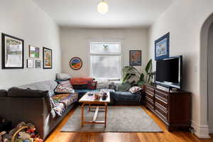 Living room featuring arched walkways and light wood finished floors