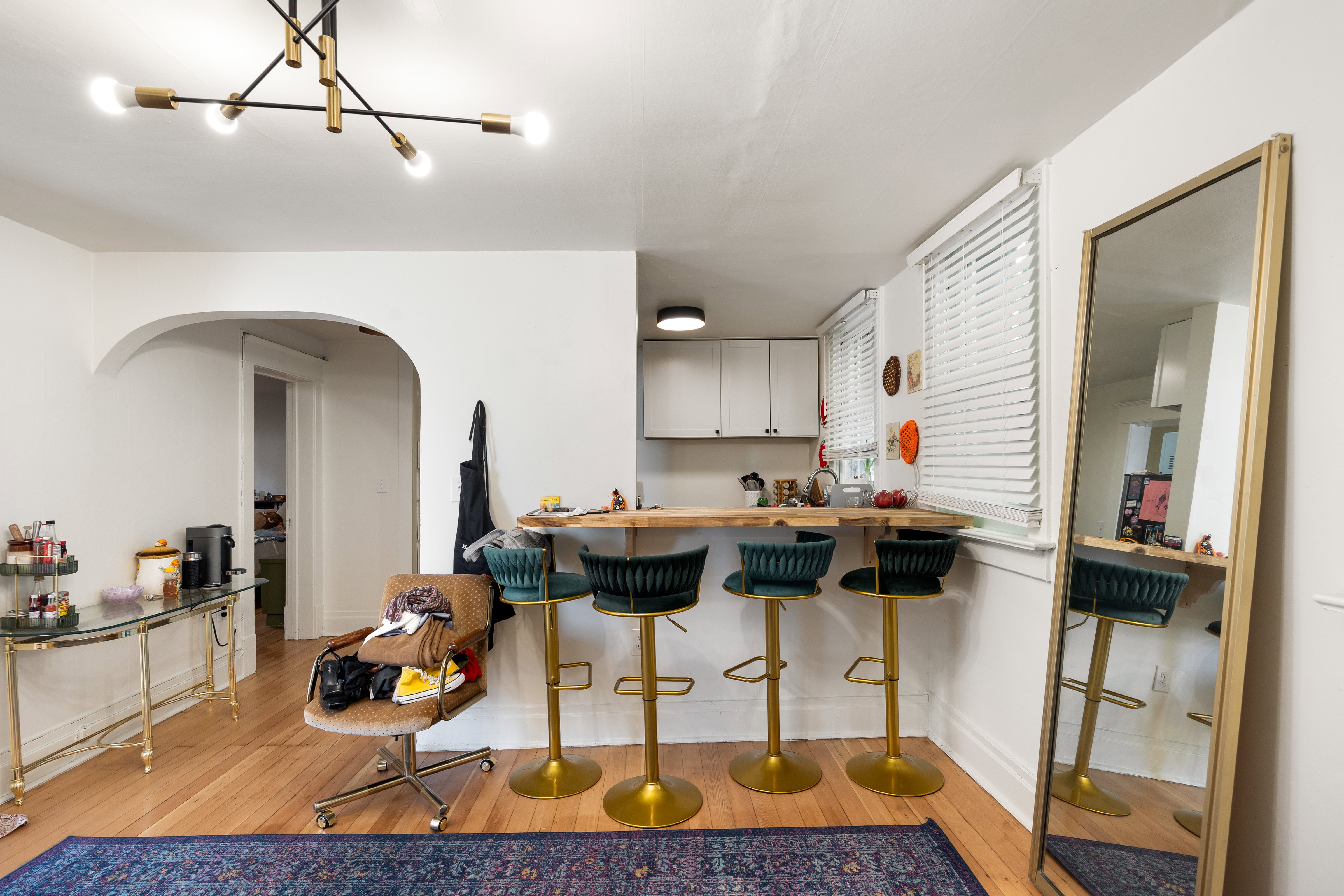 Kitchen featuring a kitchen bar, light wood-style floors, arched walkways, butcher block counters, and gray cabinetry