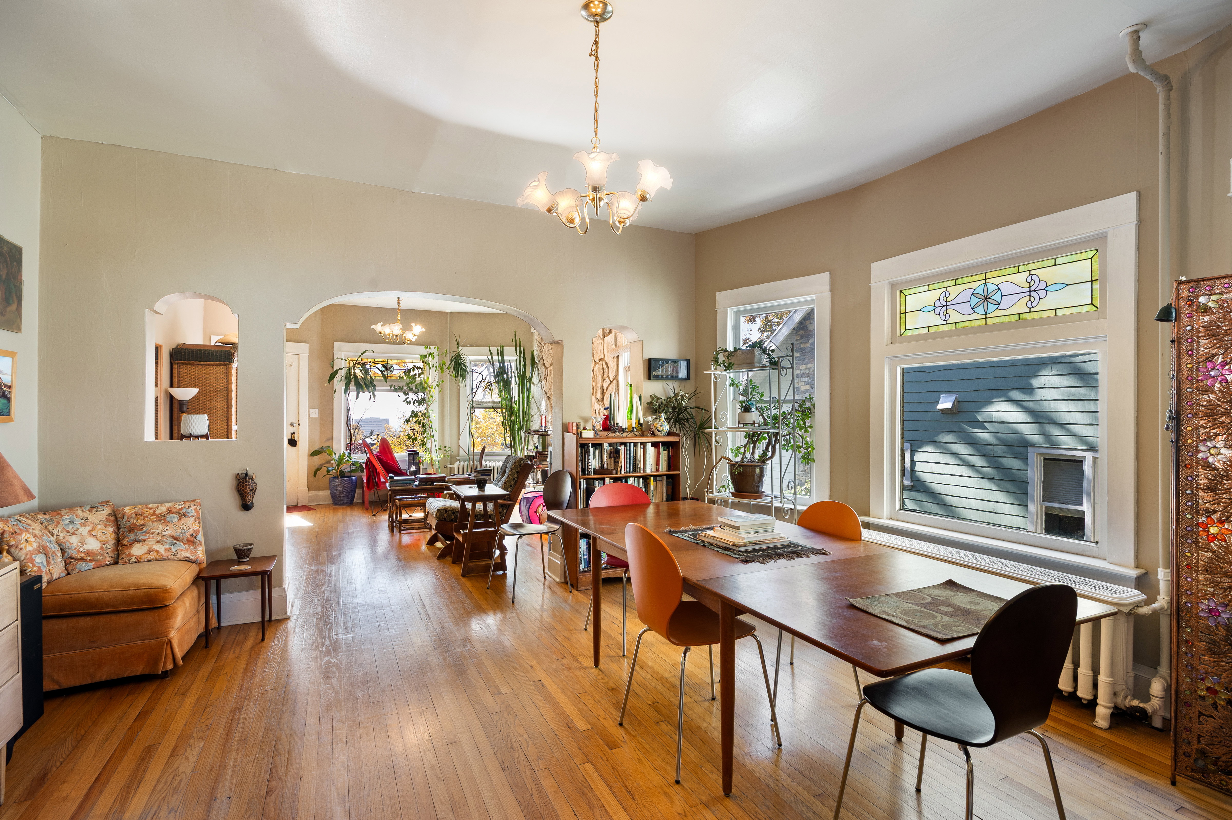 Dining space featuring arched walkways, a chandelier, and hardwood / wood-style floors