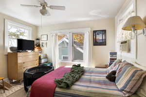 Bedroom featuring a ceiling fan, carpet, and cooling unit