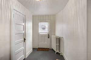 Doorway with radiator heating unit and concrete flooring