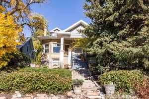 View of front of house featuring brick siding and stairway