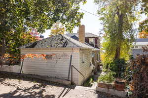 View of property exterior with a garden and a chimney