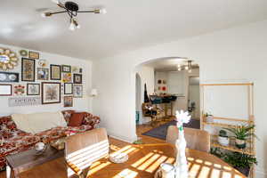 Living area featuring wood finished floors, arched walkways, and a chandelier