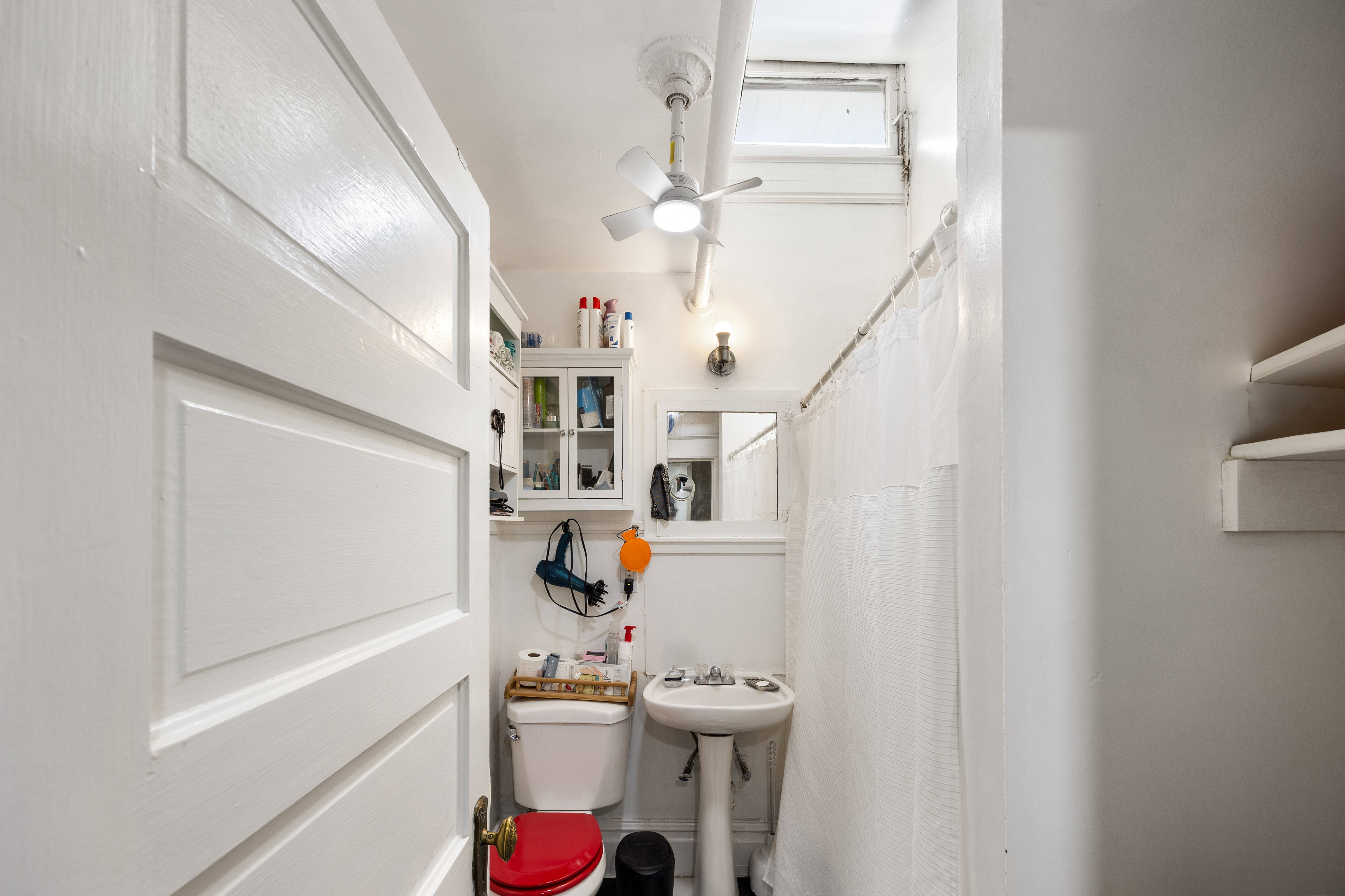 Bathroom featuring curtained shower and ceiling fan