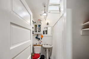Bathroom featuring curtained shower and ceiling fan