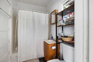 Full bath featuring curtained shower and vanity