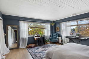 Bedroom with multiple windows and wood finished floors