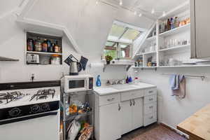 Kitchen featuring white appliances, white cabinetry, wooden counters, and open shelves