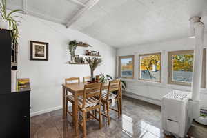 Dining area featuring vaulted ceiling and a baseboard radiator