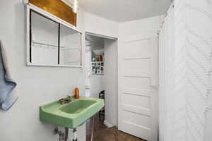 Full bathroom with dark tile patterned flooring and curtained shower