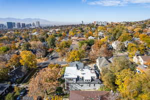 Aerial view of property and surrounding area with a mountain backdrop and nearby urban area