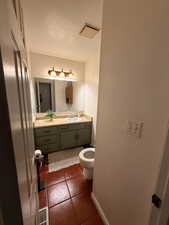 Half bathroom with vanity and a textured ceiling