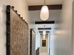 Corridor with beam ceiling and carpet flooring