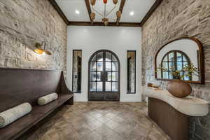 Foyer featuring french doors, an accent wall, and a high ceiling
