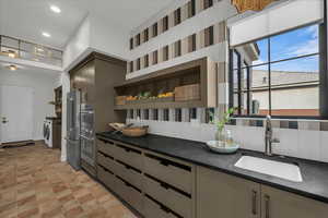 Scullery Kitchen with open shelves, stainless steel appliances, independent washer and dryer, recessed lighting, and dark stone countertops