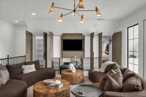 Living room with vaulted ceiling and suspended lighting
