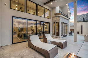 Patio terrace at dusk with a patio and a fire pit