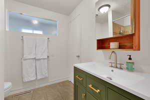 Full bathroom with vanity, light tile patterned floors, and a shower
