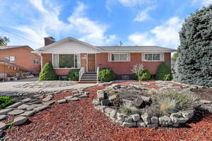 Ranch-style home featuring brick siding and a chimney