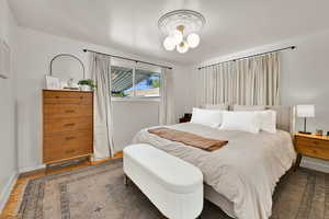 Bedroom with wood finished floors and baseboards