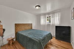 Bedroom with light wood finished floors and baseboards