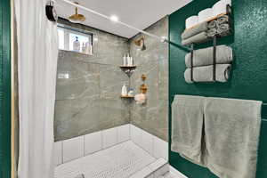 Full bath featuring a shower stall and a textured wall