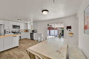 Dining room with a textured ceiling and wood tiled floors