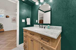 Bathroom with vanity and a textured wall