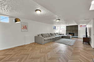 Living room with a brick fireplace and a textured ceiling