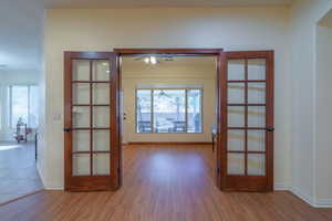Large window in bonus room/2nd den featuring LVP flooring, a ceiling fan, and french doors
