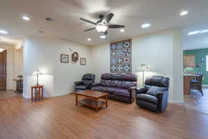 Living area featuring commercial grade LVP light wood-style flooring, recessed lighting, and a ceiling fan