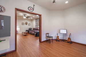 Large double door bonus room with lots of natural lighting, LVP light wood floors, ceiling fan.