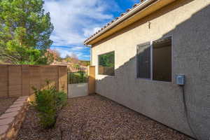Fully fenced backyard. View of side gate.