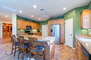 Kitchen featuring recessed lighting, a breakfast bar area, open kitchen with lot granite countertops.