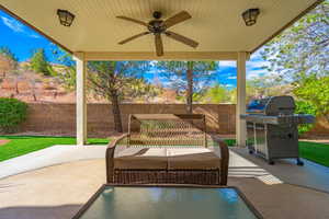 Fenced backyard featuring ceiling fan, a patio with a large shaded area with lighting.