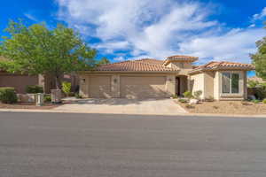 Mediterranean / spanish-style house with a garage, concrete driveway, stucco siding, and a tiled roof, 3 car garage