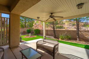 Fenced backyard with ceiling fan and a patio