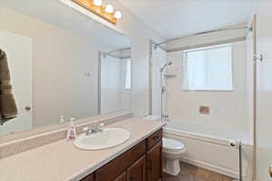 Hall Full bathroom featuring vanity, shower / washtub combination, and dark tile patterned flooring
