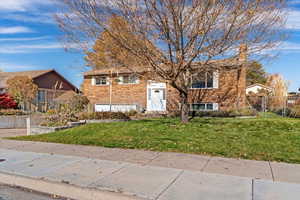 Bi-level home with brick siding and a chimney