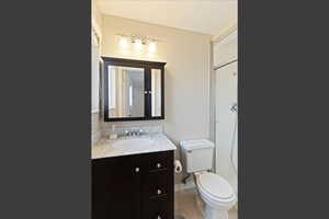 Primary 3/4 bath featuring vanity, light tile patterned flooring, and a stall shower