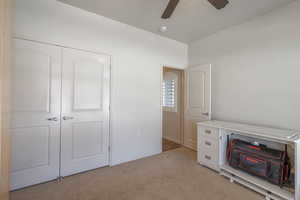 2nd bedroom with light carpet, a closet, and a ceiling fan