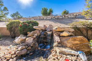 Exterior view of a waterfall and a fenced backyard