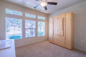 2nd bedroom featuring carpet, a wall bed, a ceiling fan, and a closet