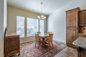 Dining space featuring a chandelier and baseboards